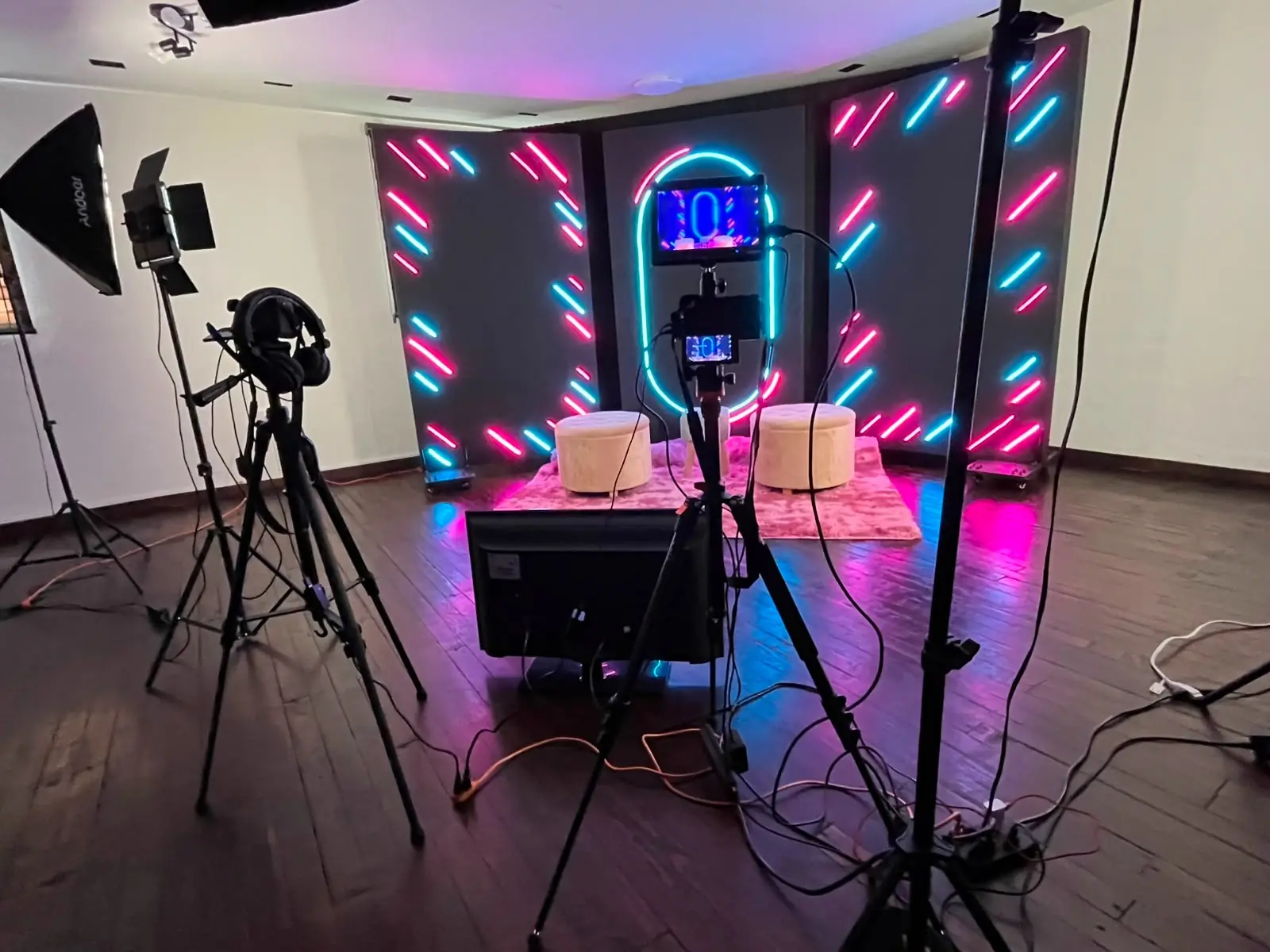 Set de podcast con líneas de neón rosa y azul y dos taburetes